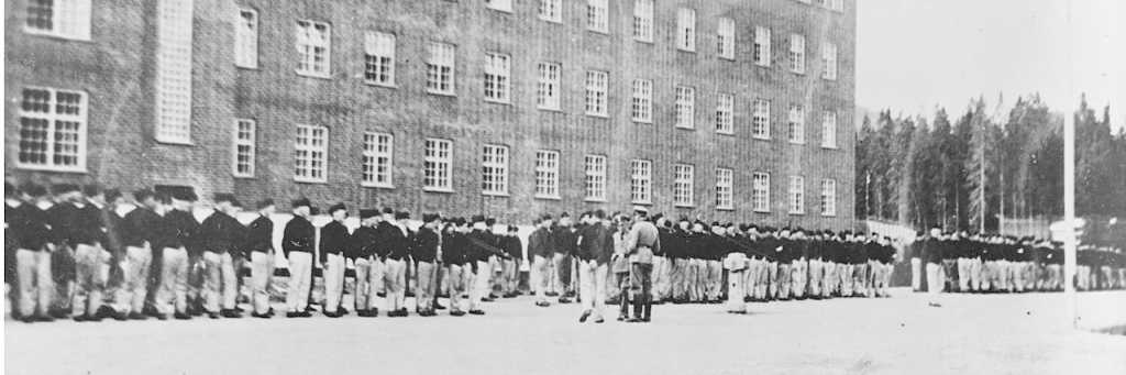 Oppstilte fanger ved Grini fangeleir fotografert mellom 1941 og 1943 (Public Domain Photo - Wikipedia).Oppstilte fanger ved Grini fangeleir fotografert mellom 1941 og 1943 (Public Domain Photo - Wikipedia).