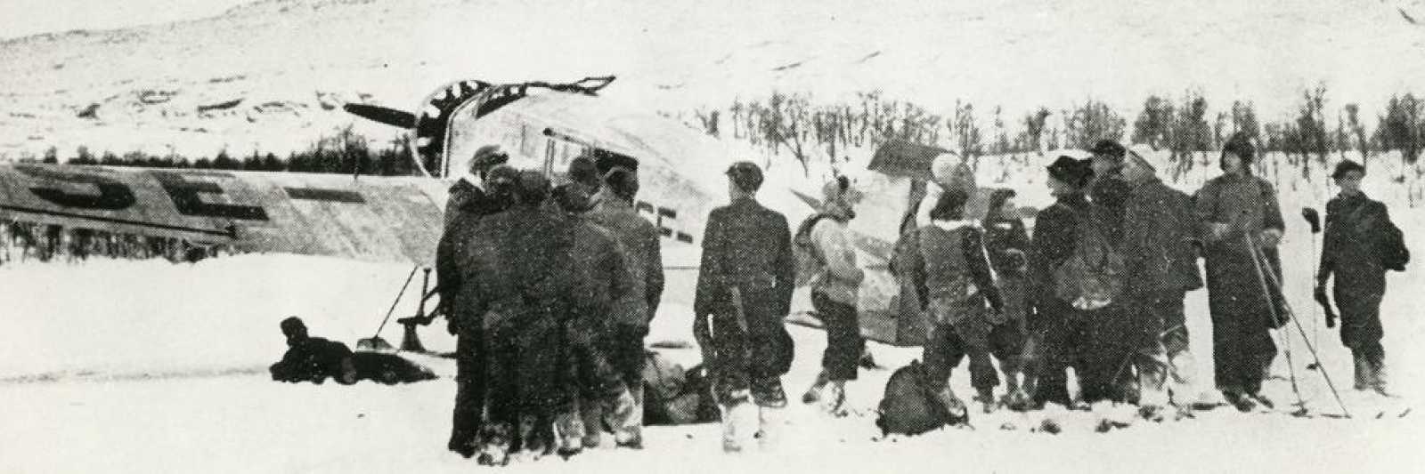 Bilde av en rekke mennesker rundt et fly i snølandskap