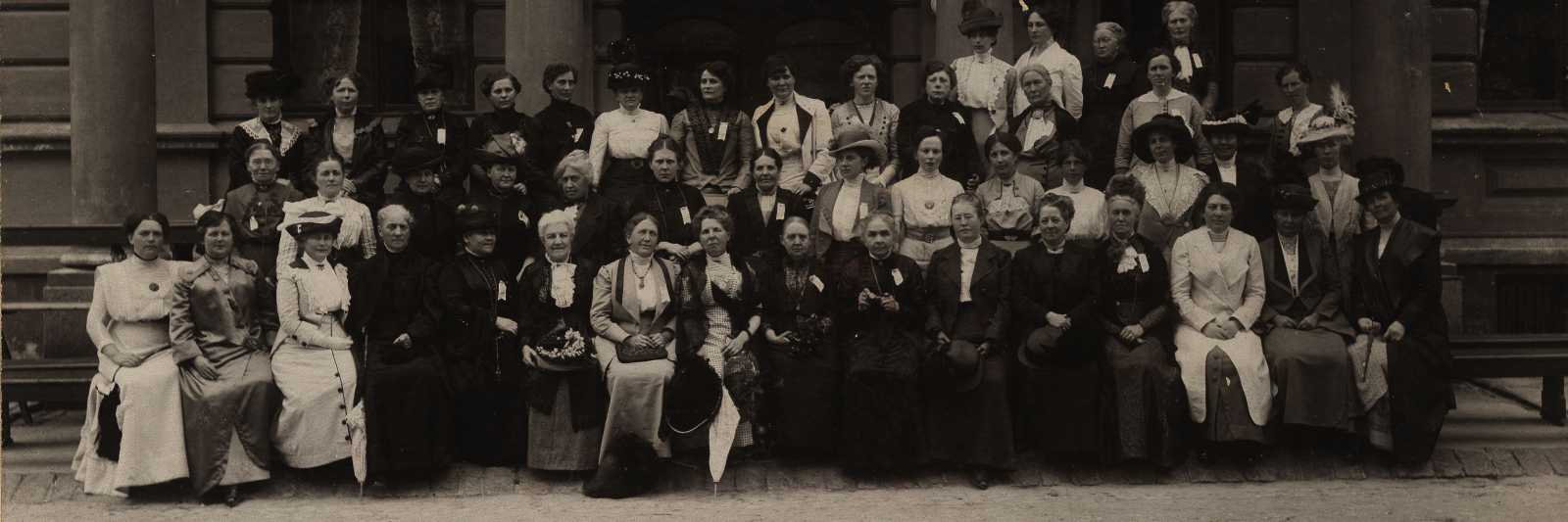 Årsmøte i Norske Kvinners Sanitetsforening i 1913. Formann Fredrikke Marie Qvam er nr. 9 fra venstre i første rekke. Fotografen er ukjend, men biletet er henta frå arkivet etter Norske Kvinners Sanitetsforening, Riksarkivet.