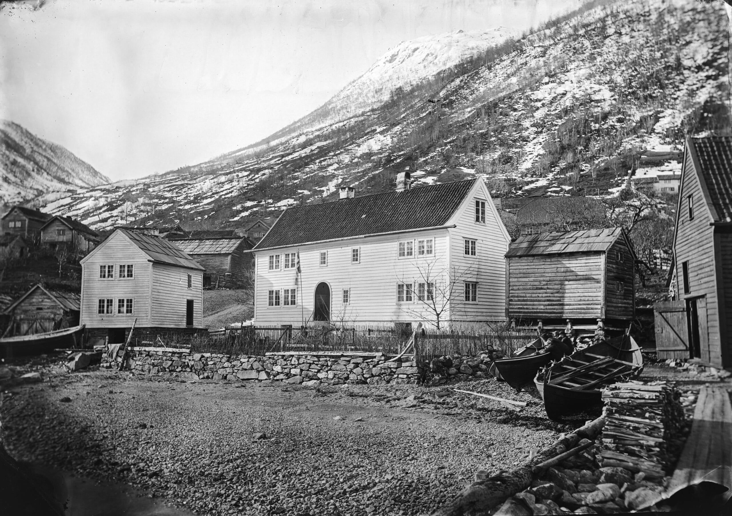 Parti fra Utne. Det store huset midt i bildet er Utne Hotel som er utvidet og påbygd flere ganger. Huset til venstre er den gamle ”tingstova” der tinget (retten) ble satt. Foto: Knud Knudsen, 1869/1870. Utlån: Billedsamlingen, UIB.