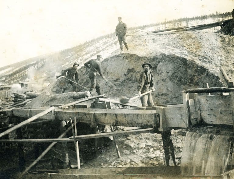 Gold panning and sluicing in summer during the Klondike Gold Rush.