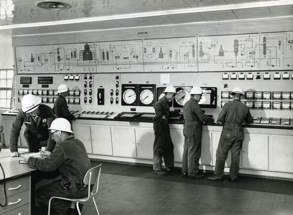 Powerformerpanelet i kontrollrommet på raffineriet i 1960. Fra høyre: Magne Grøsvik, Arne Breiner, ukjent person, Thorvald Fagerholdt, Jørgensen (skiftleder) og ukjent person. Foto: Øiesevold Reklamestudio.
