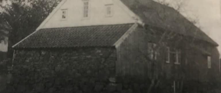 Garborgheimen med tjørebreidd austside, fotografert ca. 1960 av Peder Heskestad. Baksida viser den opphavlege overflata før seinare kvitmaling.